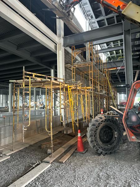 Block wall with scaffolding, steel-frame building