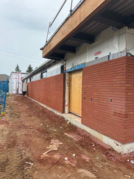 Long-format brick veneer beside an entrance