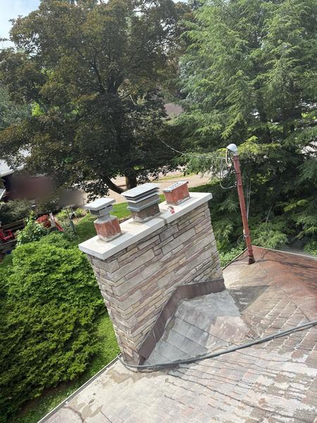 Rebuilt stone chimney with new cap and flue caps