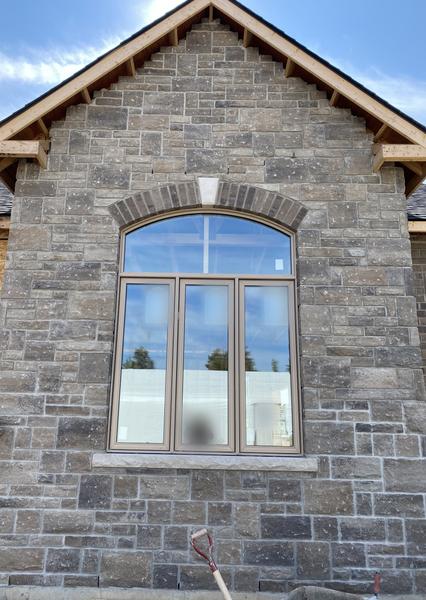 Stone gable with brick arch over window